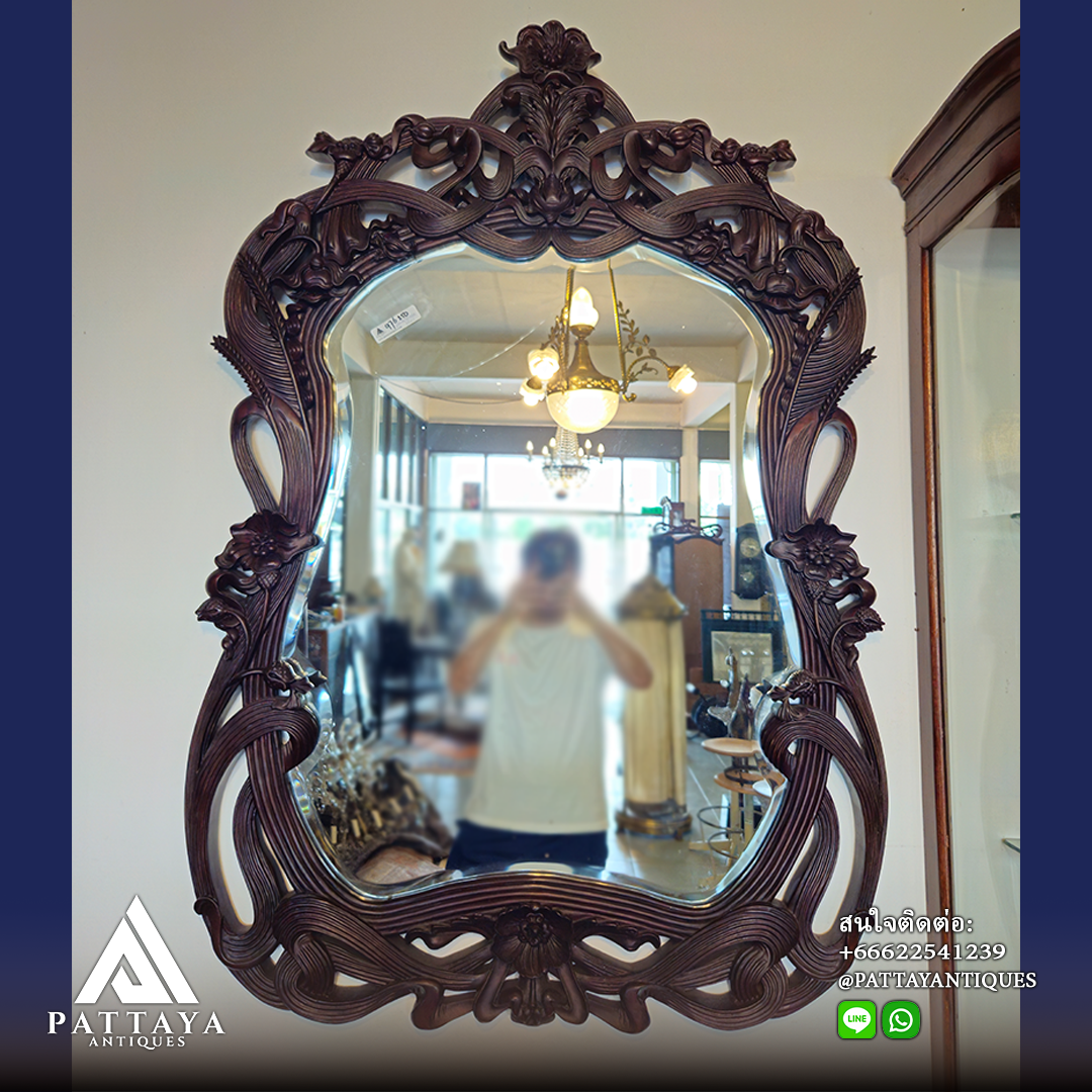 A pair of heavily carved mahogany Art Nouveau bevelled edged mirrors