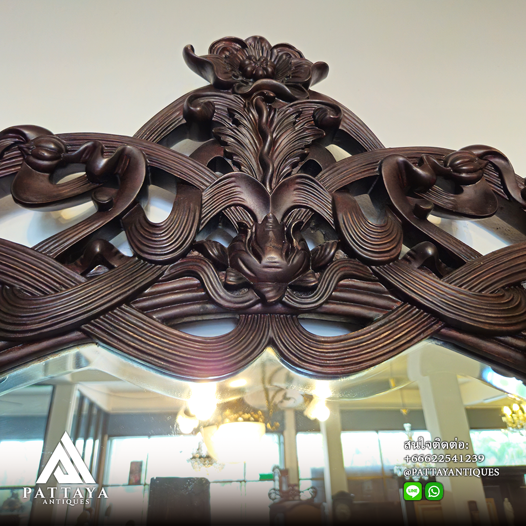 A pair of heavily carved mahogany Art Nouveau bevelled edged mirrors